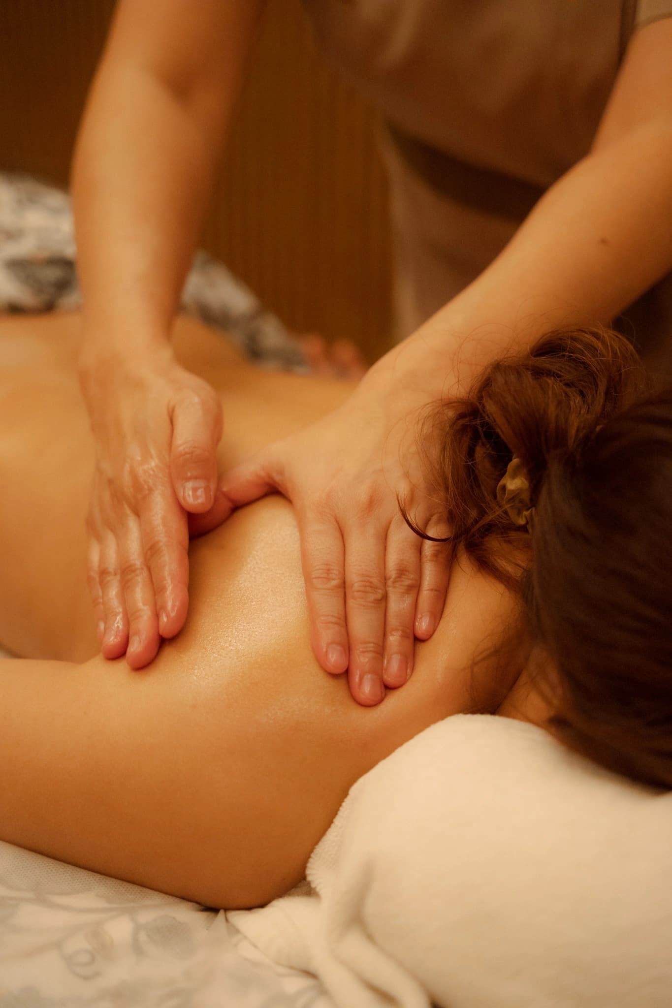 A therapist applying firm pressure across a guest's back