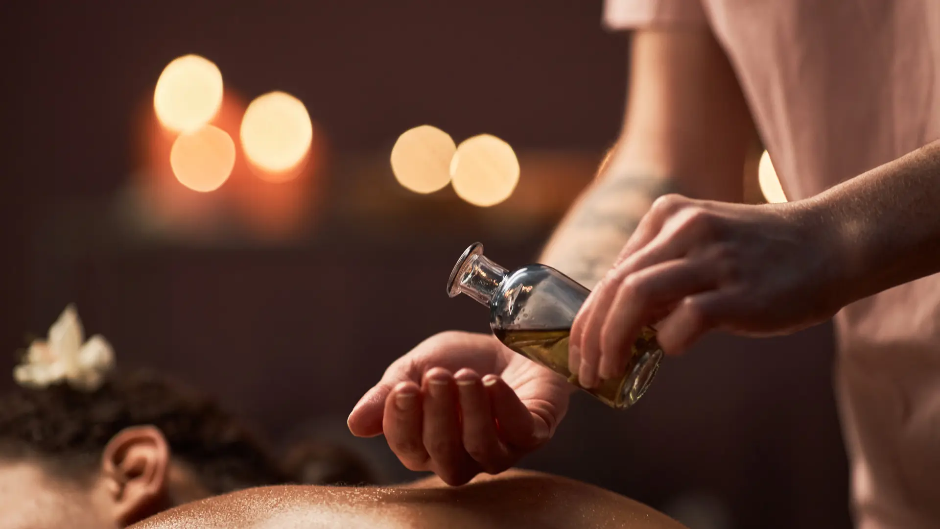 A therapist working along a guest's back with both hands